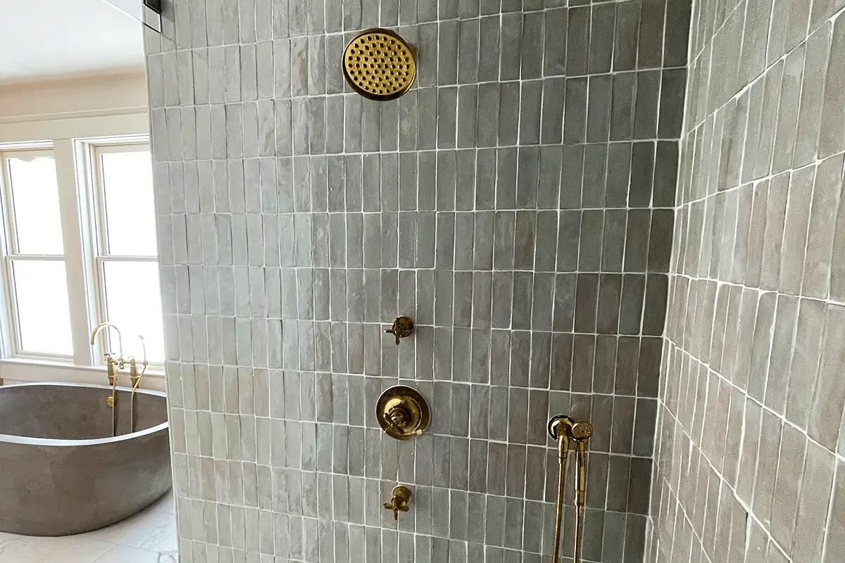 edp-brass-valve-zellige-tile-2026 Brass shower valve and fixtures on gray zellige tile — shower valve repair — EVERYDAYPLUMBER.com Tampa Bay