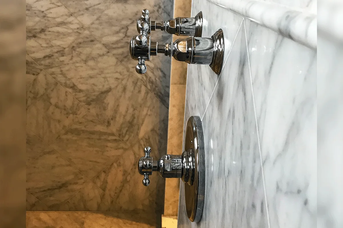 edp-chrome-two-handle-valve-repair-2026 Chrome cross-handle two-handle shower valve on marble tile — shower valve repair — EVERYDAYPLUMBER.com Tampa Bay