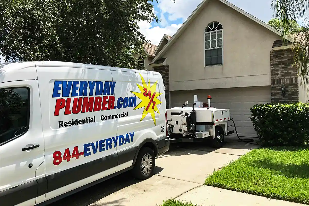 EVERYDAYPLUMBER.com service van and hydro jetting trailer parked at a Tampa Bay home — residential plumbing service call — EVERYDAYPLUMBER.com Tampa Bay