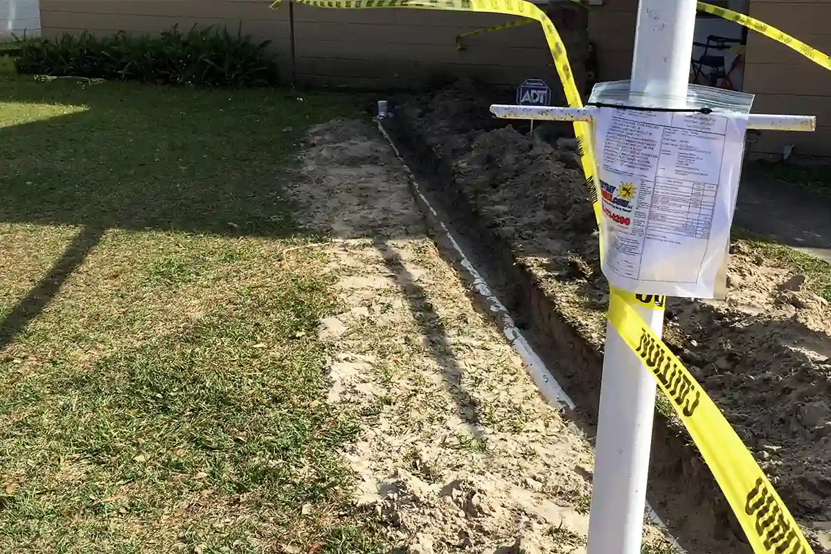 edp-repipe-trench-pipe-installation-2026 Open yard trench with new PVC pipe and posted permit tag for a whole-home repipe — whole-home repipe services — EVERYDAYPLUMBER.com Temple Terrace