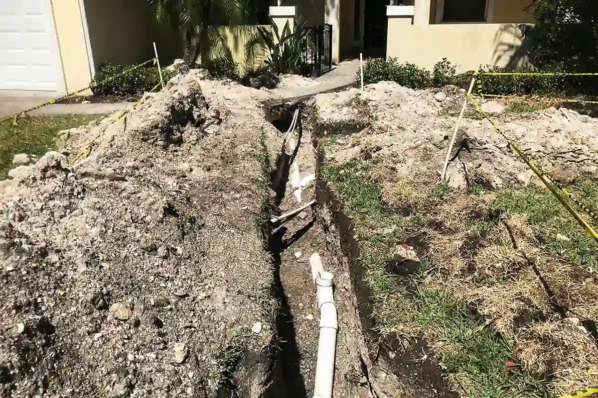 Excavated trench with new sewer line pipe laid across a Tampa Bay front yard — sewer line repair and replacement — EVERYDAYPLUMBER.com Tampa Bay