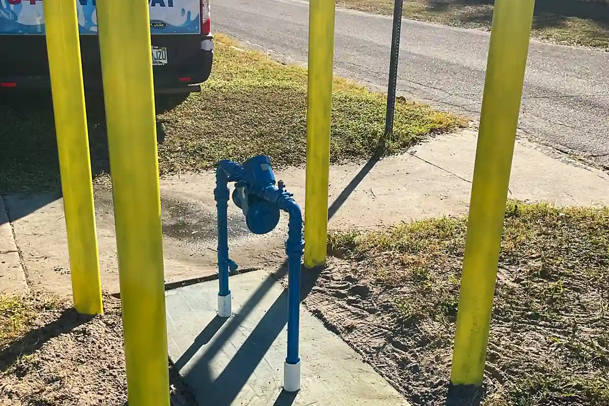 edp-tampa-backflow-repair-bollard-protected-assembly-2026 Backflow preventer protected by bollards outside a Tampa Bay commercial property — backflow and related plumbing services — EVERYDAYPLUMBER.com Tampa Bay